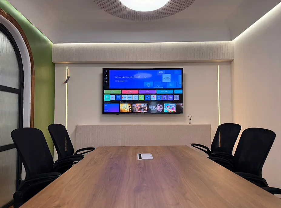 The studio boardroom with a walnut table, acoustic wall and wall mounted screen
