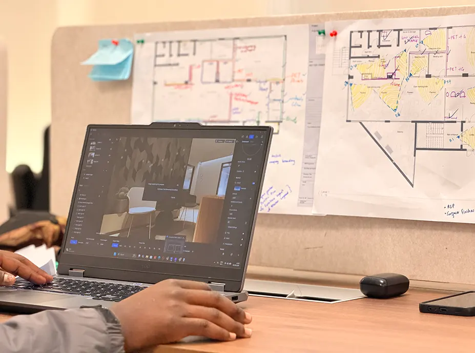 A three dimensional interior model on screen with the marked up plans behind