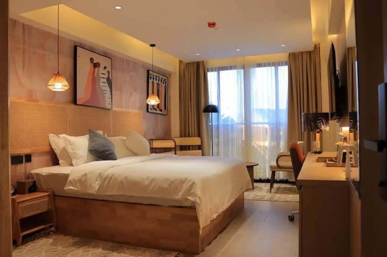 Arova Hotel guest room with rattan headboard, pendant lights and balcony glazing