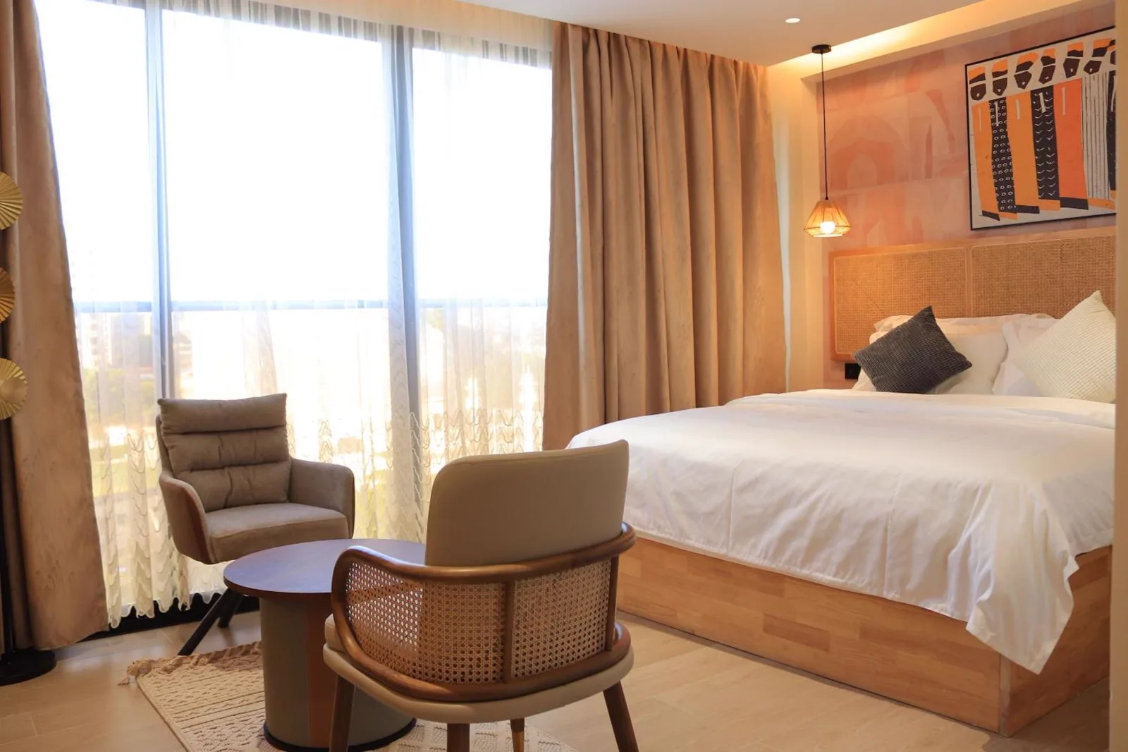 Arova Hotel guest room lounge corner with cane armchair and round timber table