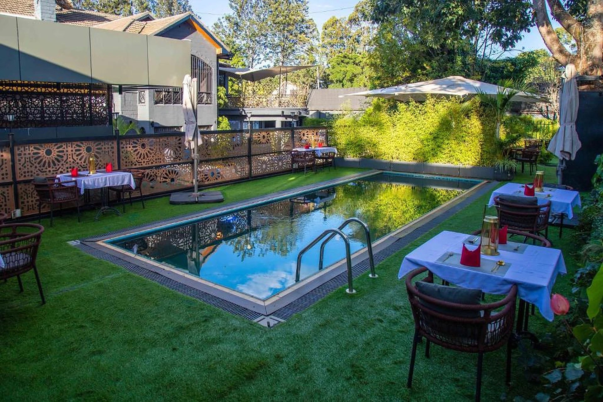 Gigiri Lion Villas pool courtyard with laser-cut screens and lawn dining