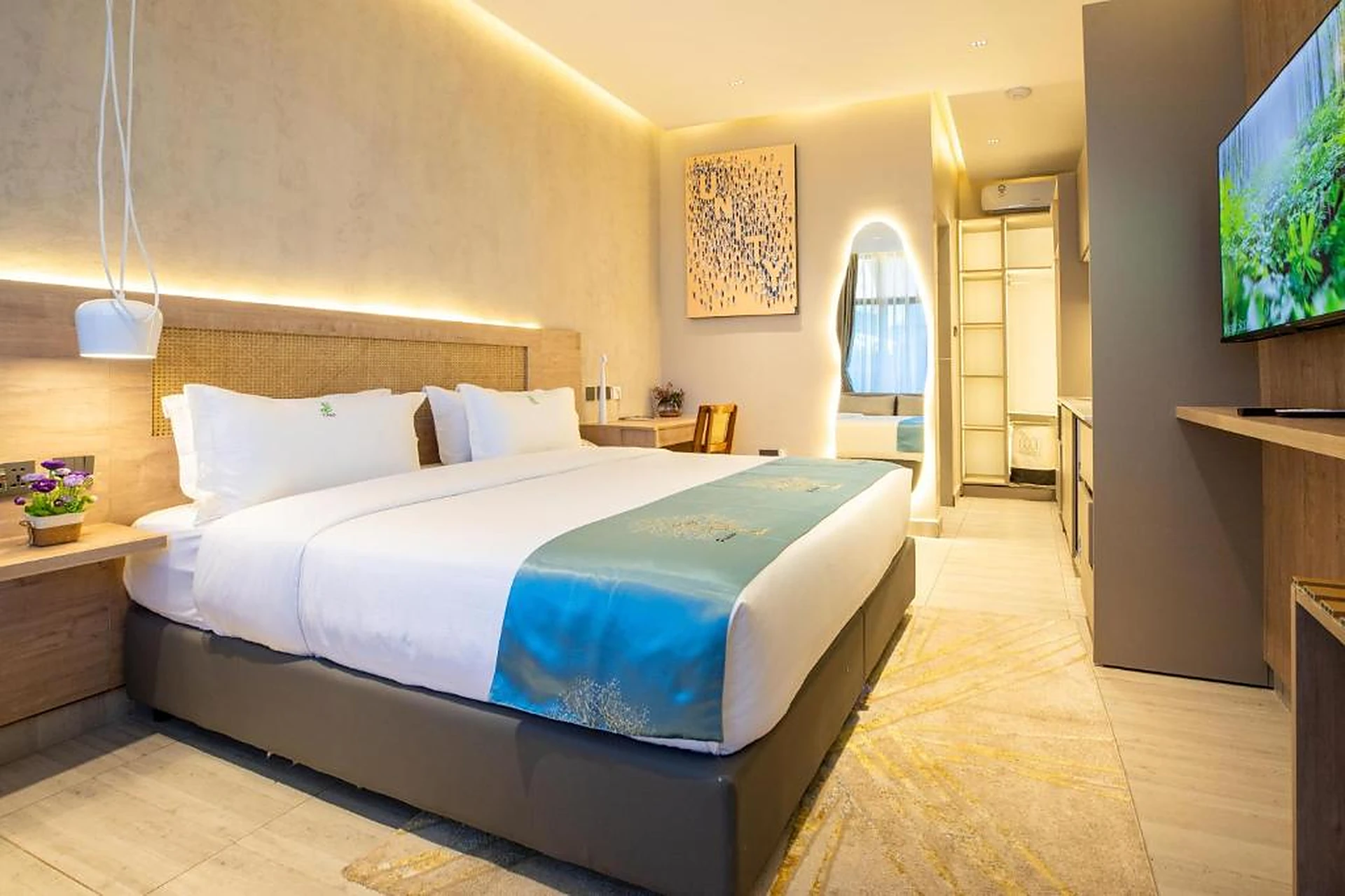 Gigiri Lion Villas guest suite with cane headboard, cove lighting and media wall