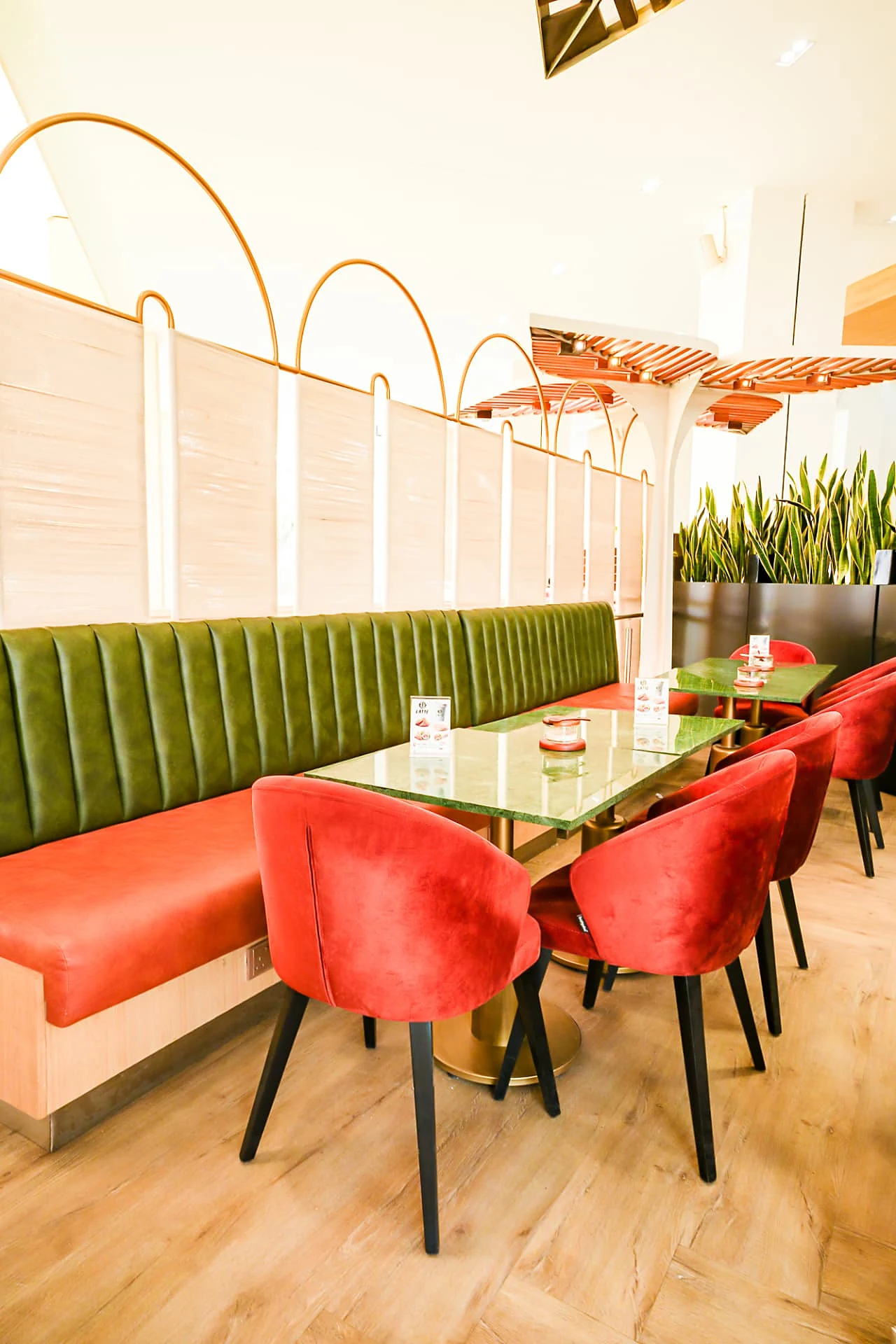 Green leather banquette with terracotta chairs