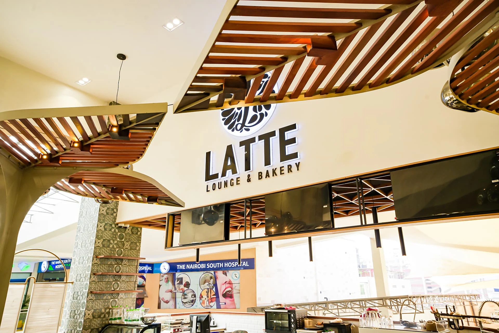 Illuminated Latte Lounge and Bakery signage with timber canopy