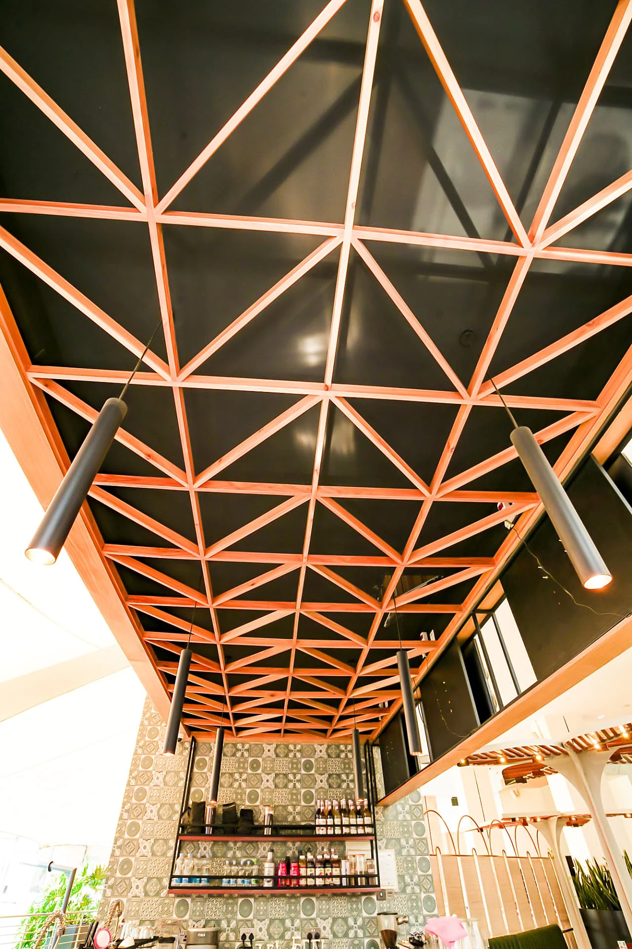Triangulated timber ceiling grid over the bar