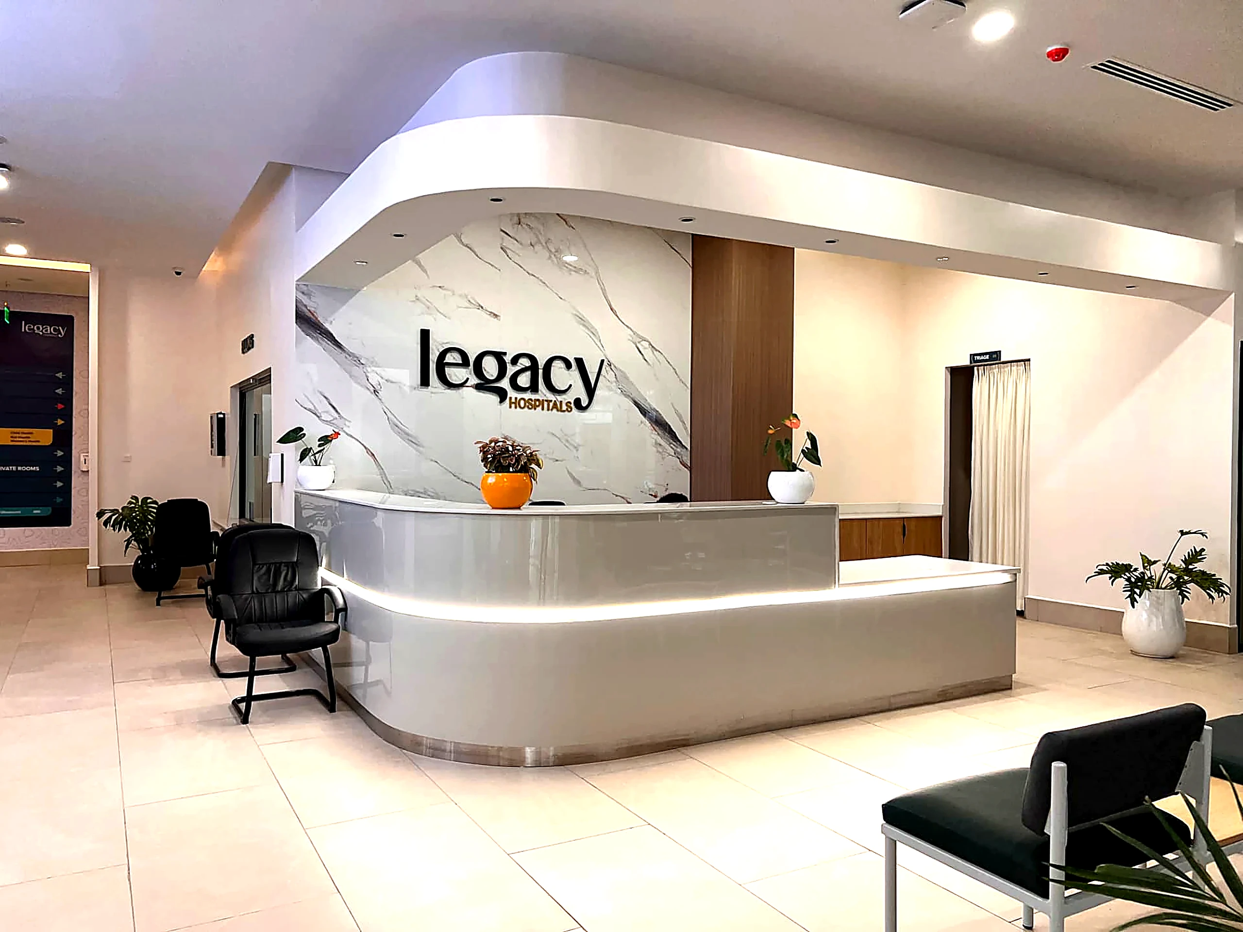 Legacy Hospitals reception with curved desk and marble feature wall