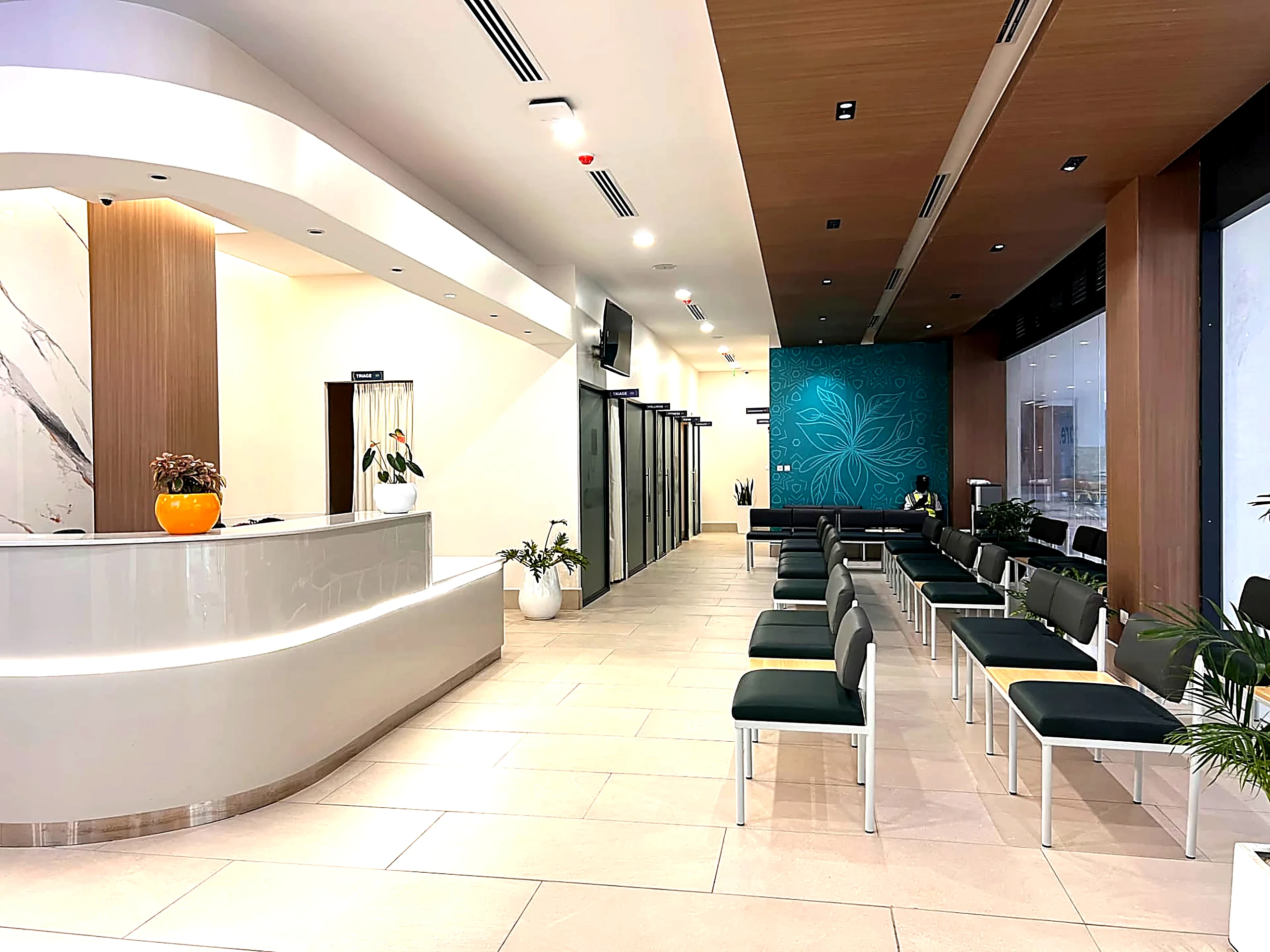 Legacy Hospitals waiting lounge with green bench seating and triage corridor