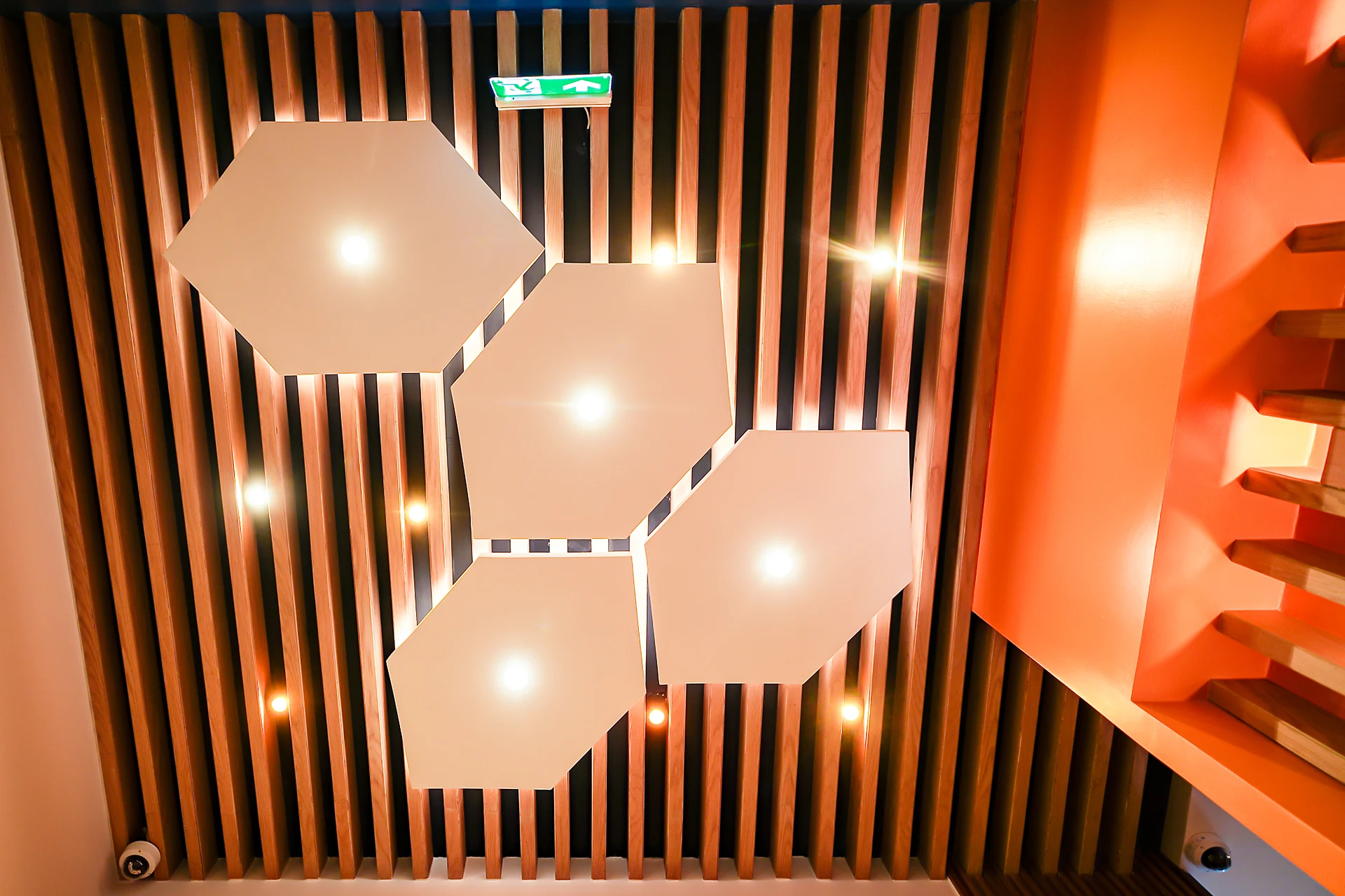 Hexagonal lit ceiling rafts over timber slats