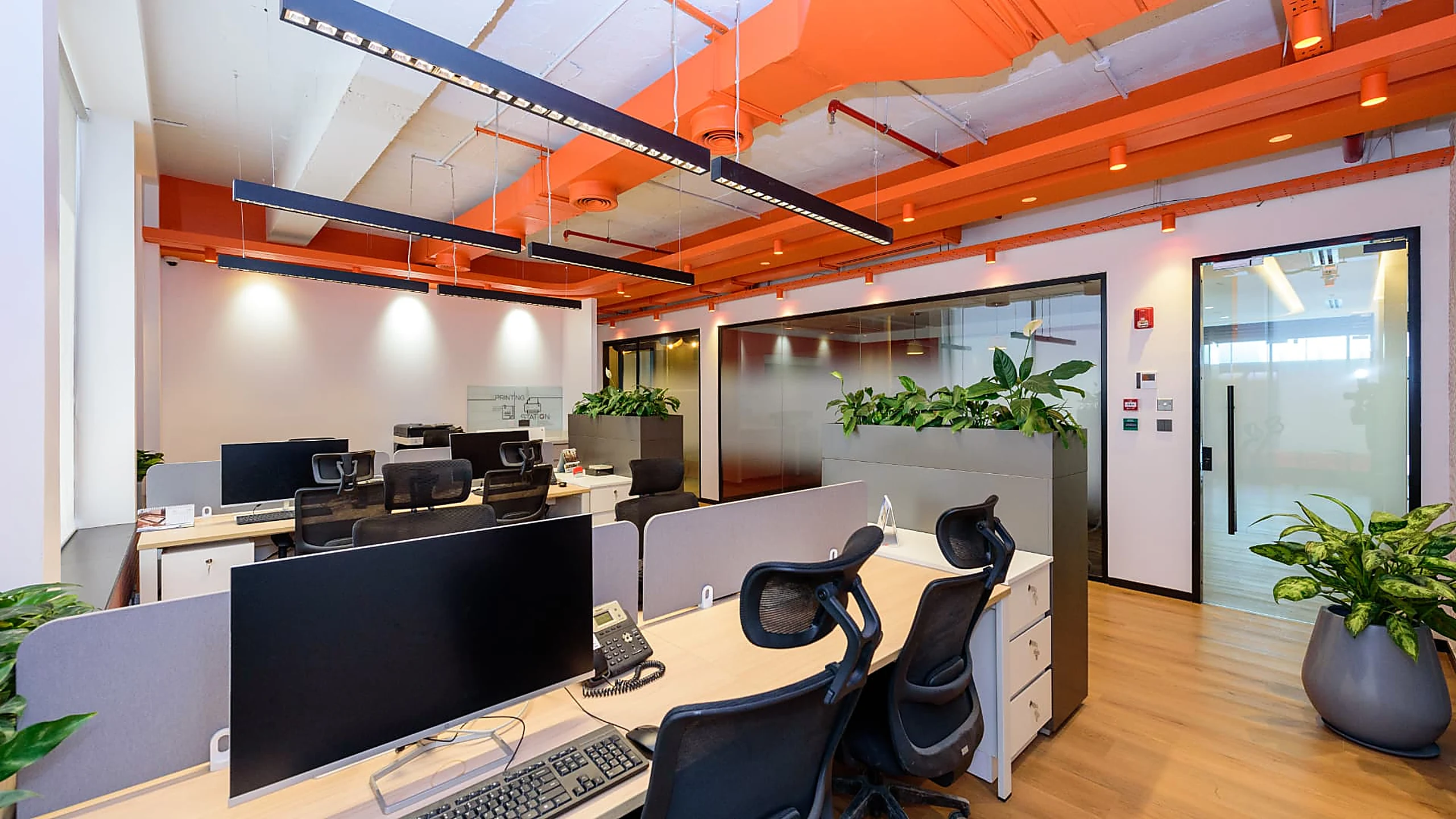 Rworld workstation bank with screens, planting and glazed meeting rooms
