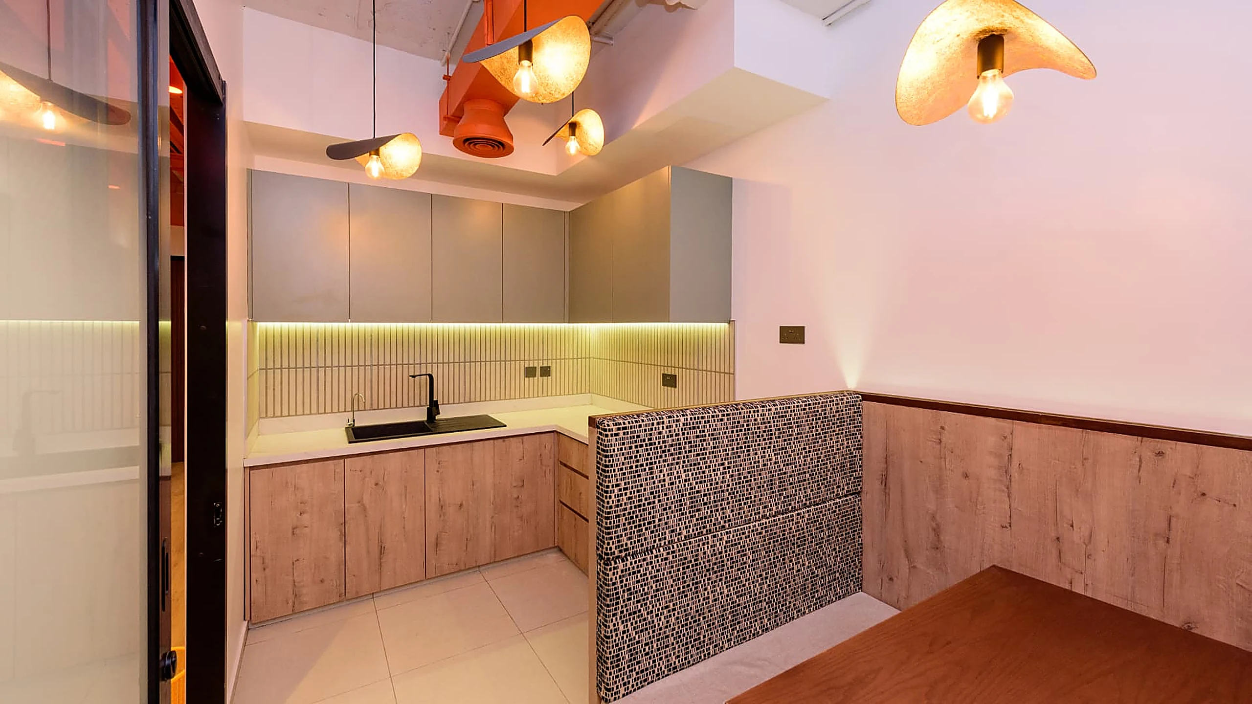 Rworld tea point with sage joinery, sculptural pendants and banquette