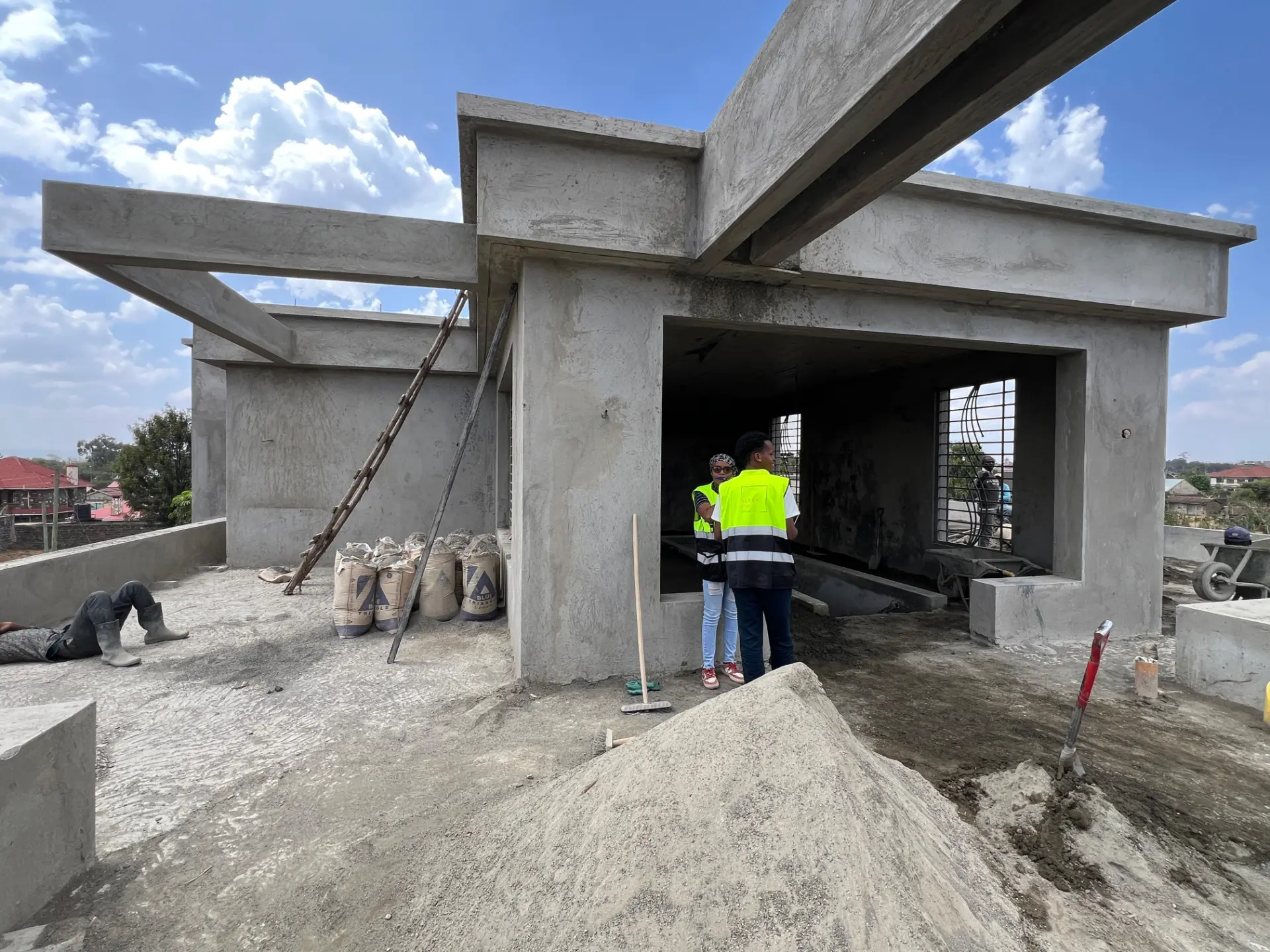 Sleek Fit Studio team in high-visibility vests reviewing progress at a concrete construction site