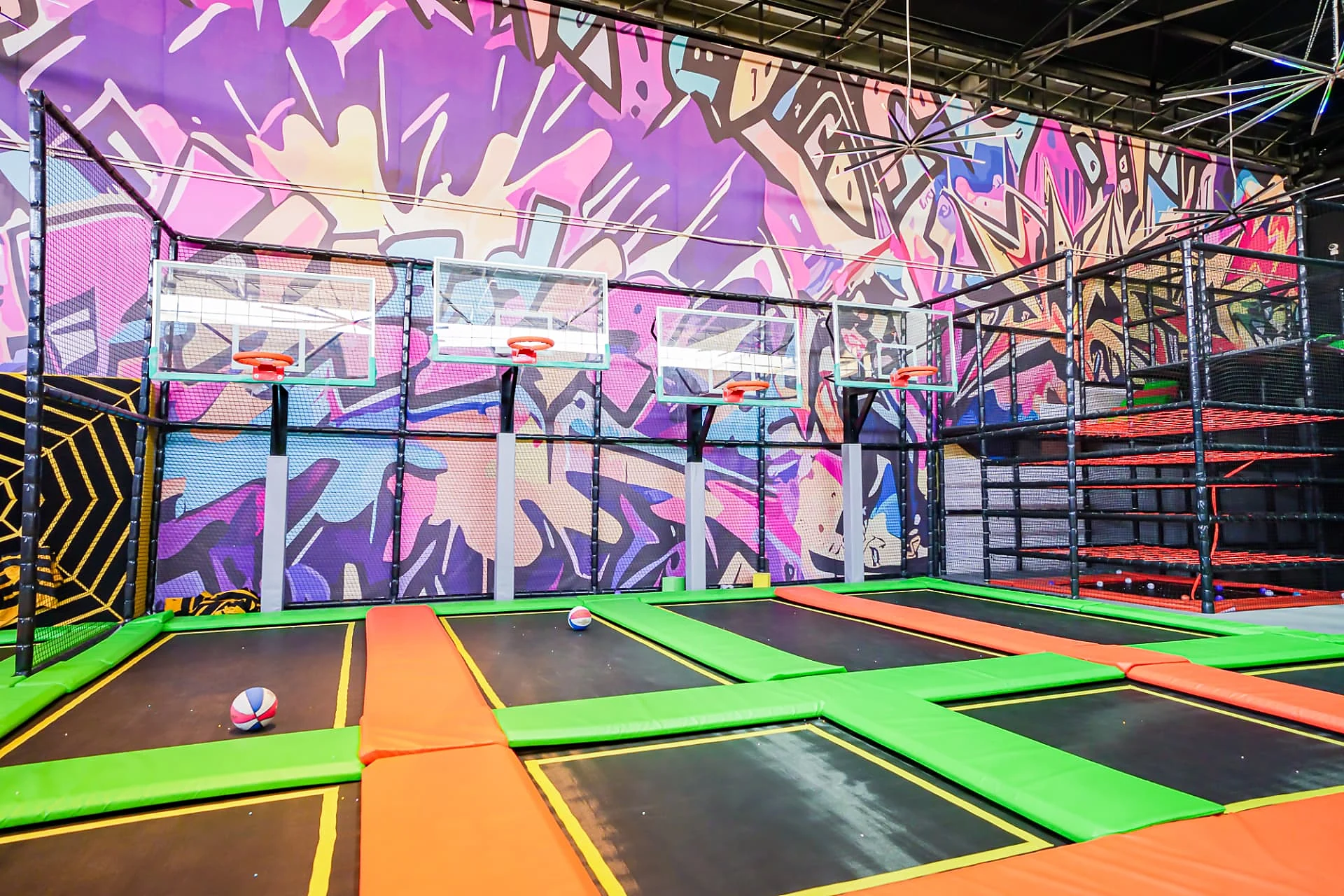 Star Jump dunk lanes with basketball hoops and graffiti mural