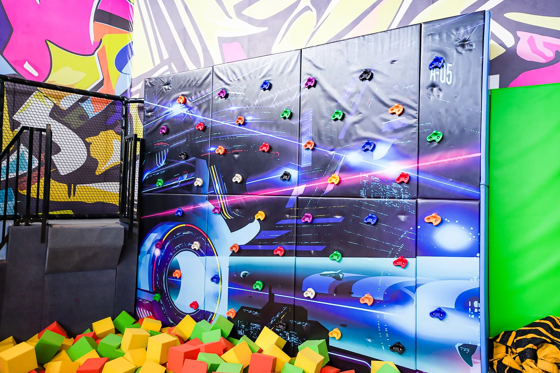 Graphic climbing wall over the foam block pit